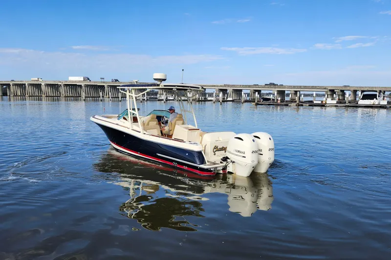 Slide: The Image of 2016 Chris-Craft Calypso 26 boat on calm water near a bridge. - 7