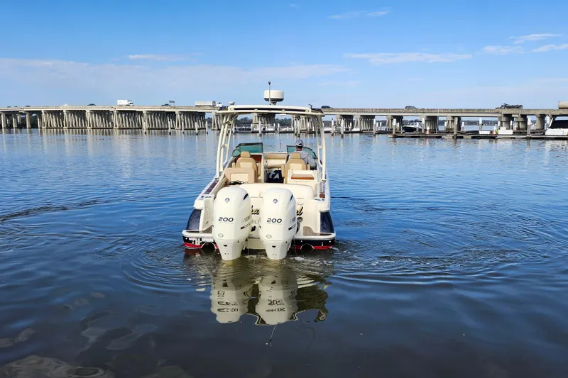Slide: The Image of 2016 Chris-Craft Calypso 26 boat on calm water near a bridge. - 9