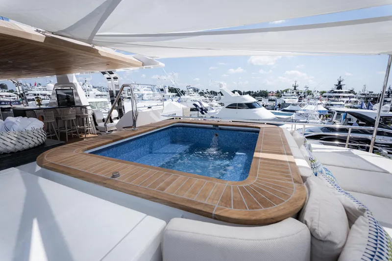 Slide: The Image of Luxurious yacht deck with hot tub, featuring Alpha Alfresco 125, 2020 model, in a marina setting. - 11