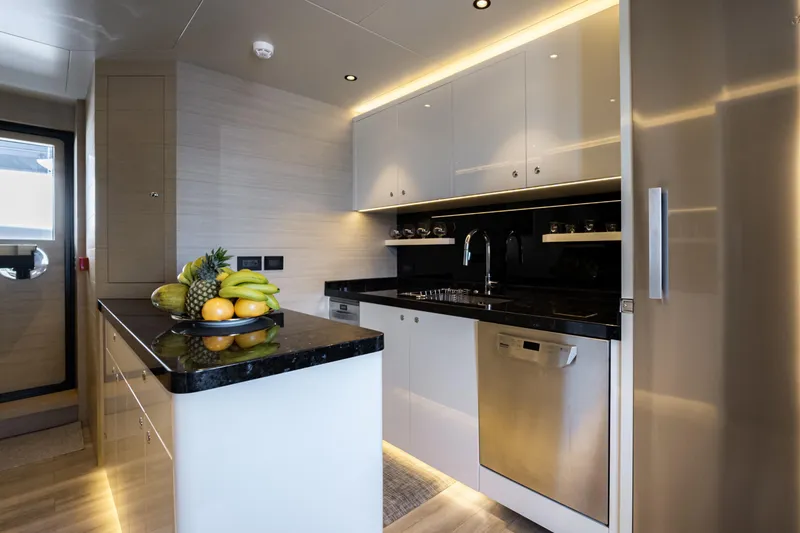 Slide: The Image of Modern yacht kitchen with sleek design, featuring fruit bowl and stainless steel appliances. - 20
