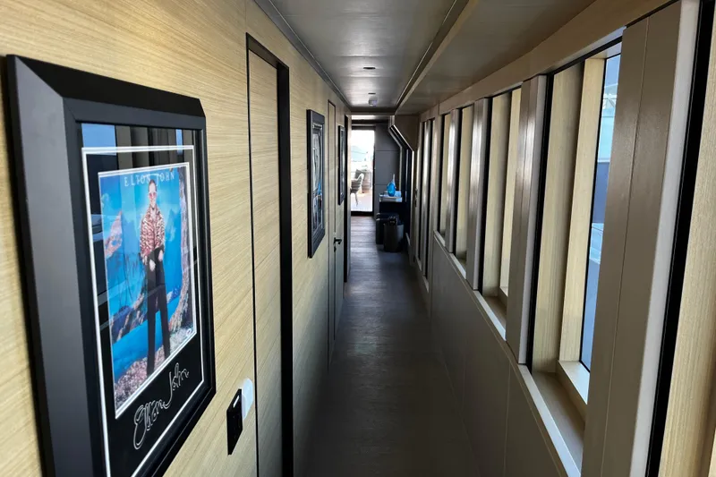 Slide: The Image of Narrow hallway in 2020 Alpha Alfresco 125 yacht with framed artwork and large windows. - 21