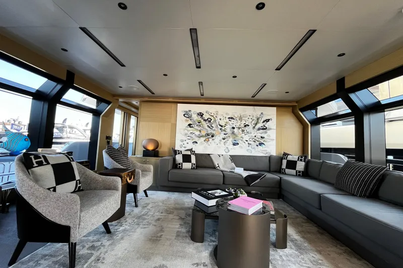 Slide: The Image of Luxurious yacht interior with modern decor, featuring a large sectional sofa and abstract wall art. - 23