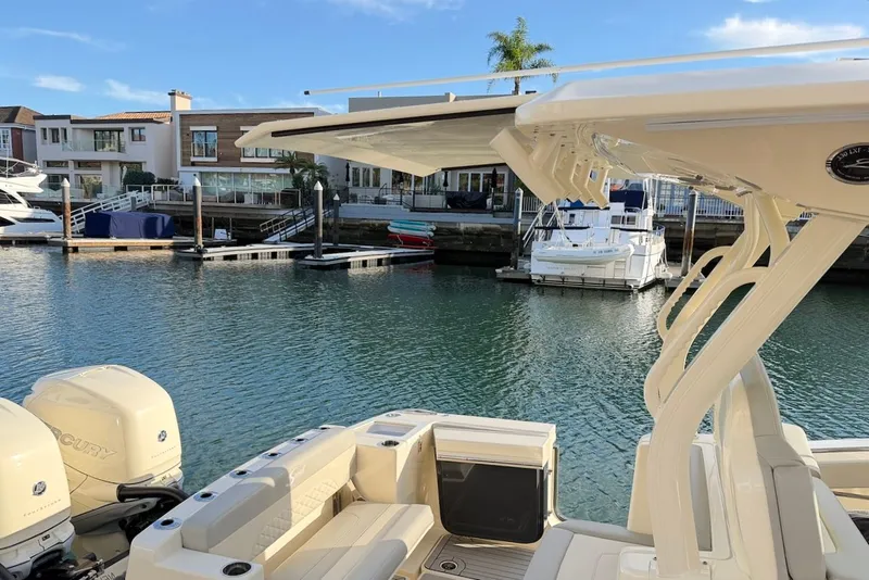 Slide: The Image of 2023 Scout 330 LXF boat docked with engines. - 12