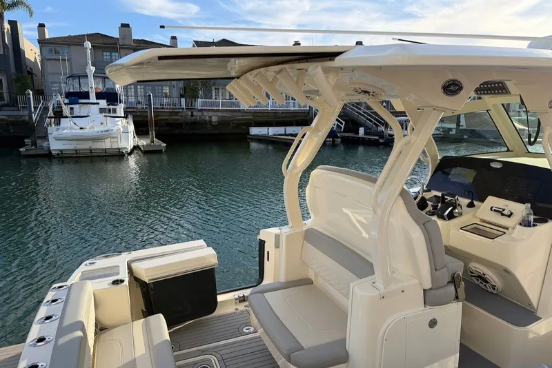 Slide: The Image of 2023 Scout 330 LXF boat docked, featuring modern design. - 13