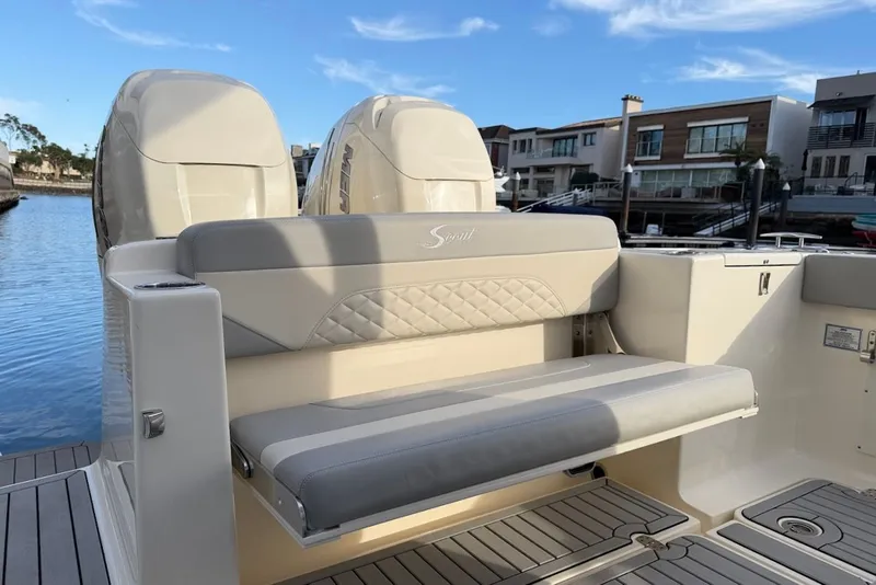 Slide: The Image of 2023 Scout 330 LXF boat with luxurious seating by the water. - 14