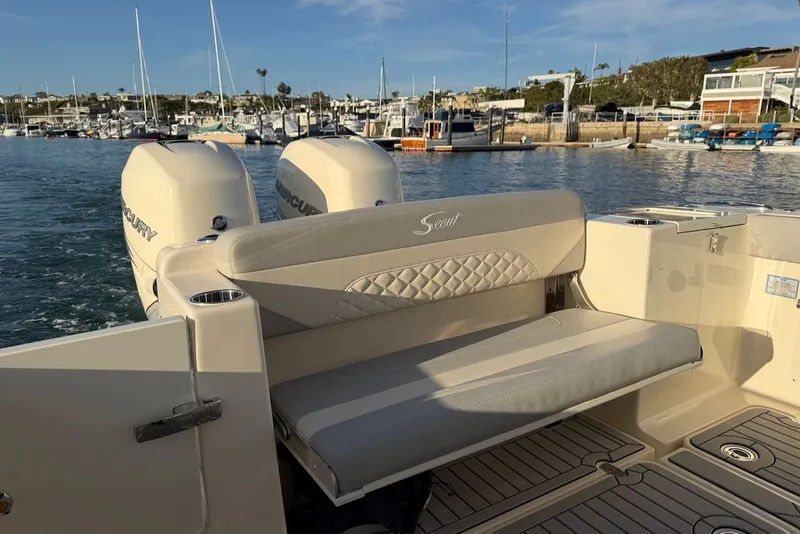 Slide: The Image of 2023 Scout 330 LXF boat with luxurious seating at the harbor. - 15