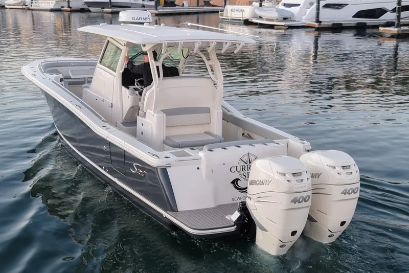 Slide: The Image of 2023 Scout 330 LXF boat with twin Mercury 400 engines on water. - 2