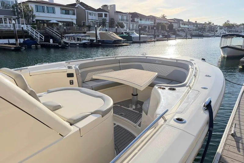 Slide: The Image of 2023 Scout 330 LXF boat docked with seating area. - 21