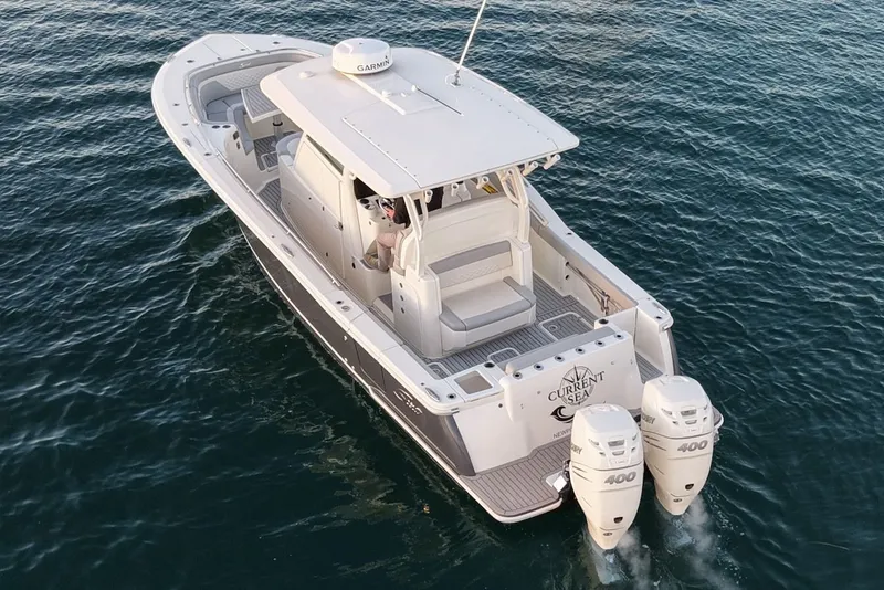 Slide: The Image of Scout 330 LXF 2023 boat on water with dual outboard engines. - 3