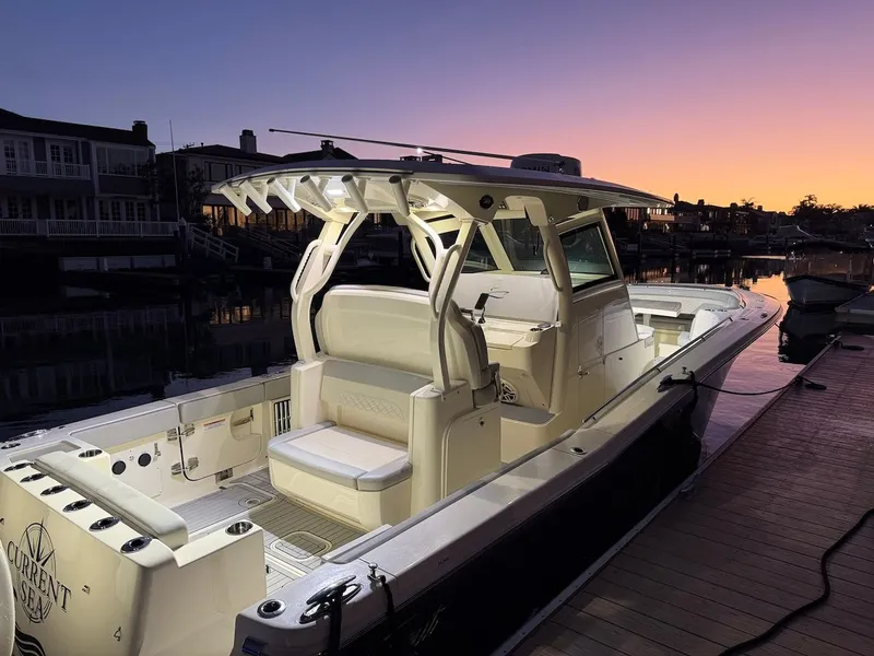 Slide: The Image of 2023 Scout 330 LXF boat docked at sunset. - 6