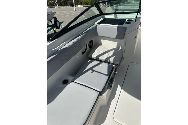 Slide: The Image of 2022 Sea Ray SPX 210 Outboard boat interior with gray seating in a parking lot. - 19