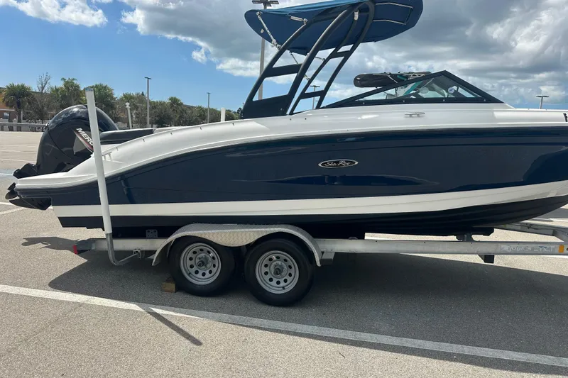 Slide: The Image of 2022 Sea Ray SPX 210 Outboard boat on trailer in sunny parking lot. - 2