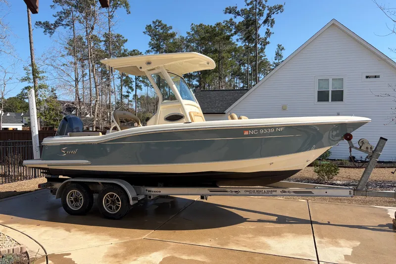 The Image of 2017 Scout 225 XSF boat on trailer, parked in residential driveway. - 0