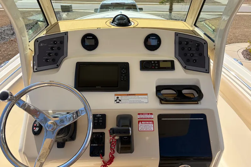 Slide: The Image of 2017 Scout 225 XSF boat dashboard with steering wheel and navigation controls. - 18