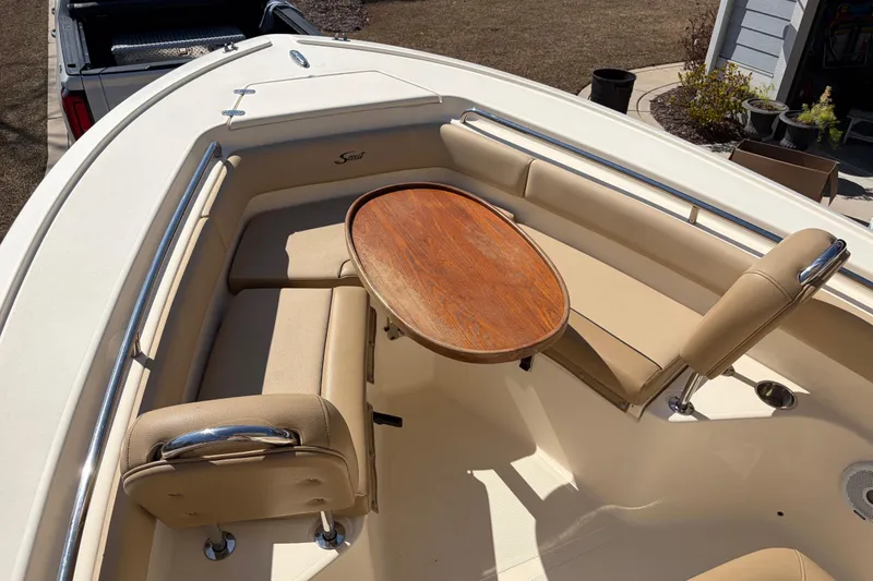 Slide: The Image of 2017 Scout 225 XSF boat interior with beige seating and wooden table. - 19