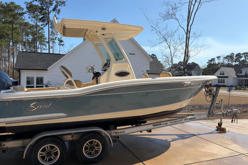 Slide: The Image of 2017 Scout 225 XSF boat on trailer in residential driveway, sunny day. - 2