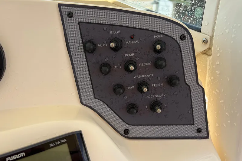 Slide: The Image of Control panel of a 2017 Scout 225 XSF boat with various switches. - 28
