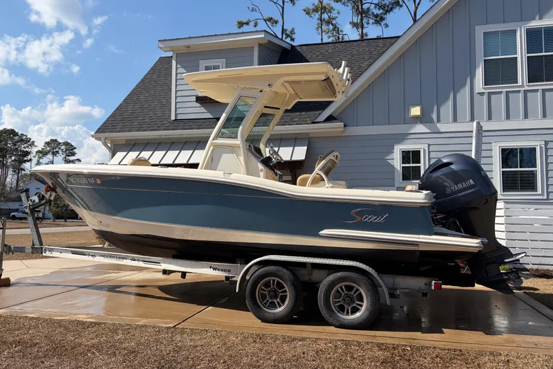 Slide: The Image of 2017 Scout 225 XSF boat on trailer, parked near a house with Yamaha engine. - 7