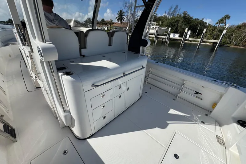 Slide: The Image of 2017 Edgewater 368CC boat interior with seating and storage, dockside view. - 10