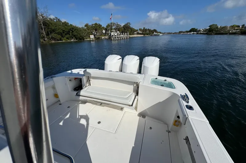Slide: The Image of 2017 Edgewater 368CC boat on calm water, featuring spacious deck and triple engines. - 12