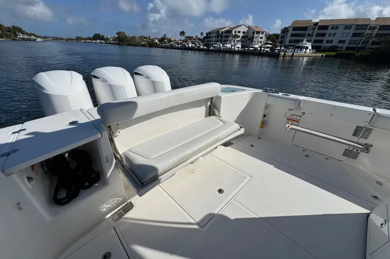 Slide: The Image of 2017 Edgewater 368CC boat with seating, docked by waterfront buildings. - 13