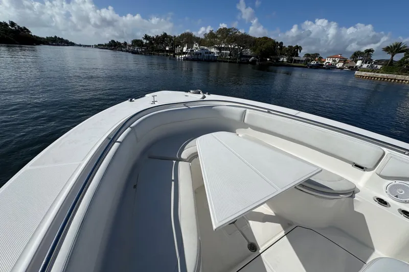 Slide: The Image of 2017 Edgewater 368CC boat with seating area and table on calm water. - 15
