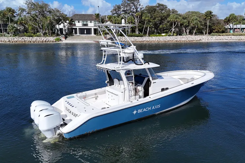 Slide: The Image of 2017 Edgewater 368CC boat cruising on a calm river near a scenic shoreline. - 5