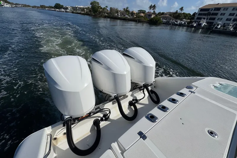 Slide: The Image of 2017 Edgewater 368CC boat with triple outboard engines cruising on a scenic waterway. - 9