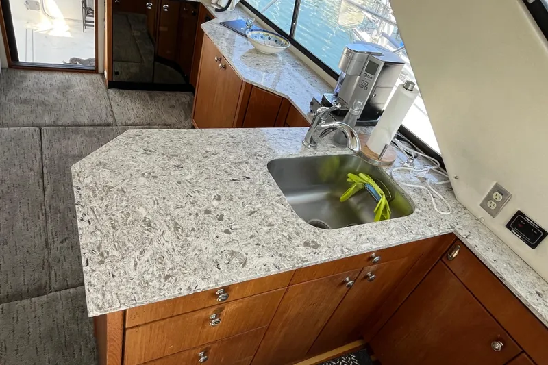 Slide: The Image of 1996 Bayliner 3788 Command Bridge Motoryacht kitchen with granite countertops and stainless steel sink. - 19