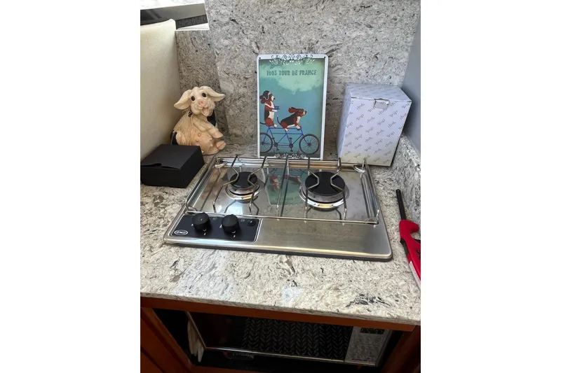 Slide: The Image of Compact kitchen area in a 1996 Bayliner 3788 Command Bridge Motoryacht with a two-burner stove. - 22