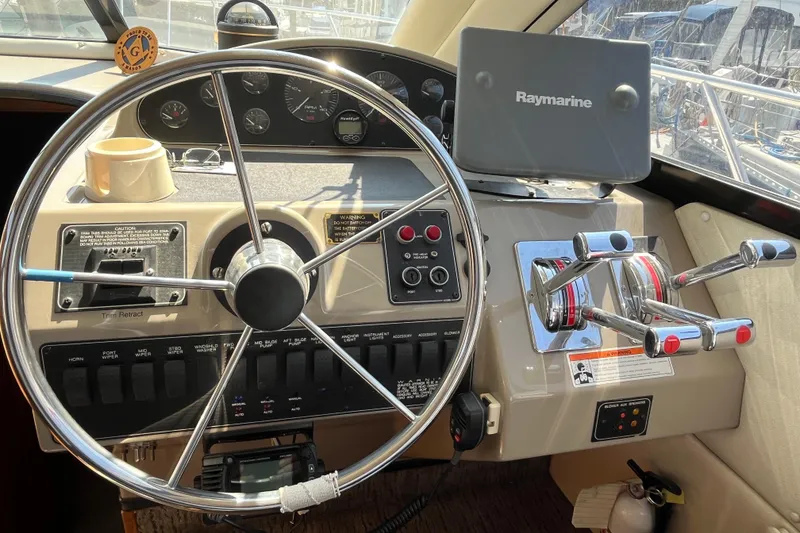 Slide: The Image of 1996 Bayliner 3788 Command Bridge Motoryacht helm with steering wheel and Raymarine navigation system. - 23