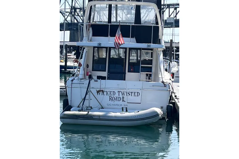 Slide: The Image of 1996 Bayliner 3788 Command Bridge Motoryacht docked, displaying "Wicked Twisted Road" name. - 3
