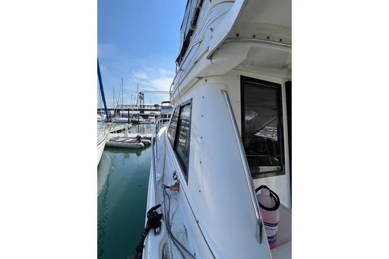 Slide: The Image of 1996 Bayliner 3788 Command Bridge Motoryacht docked in a marina, clear sky above. - 42
