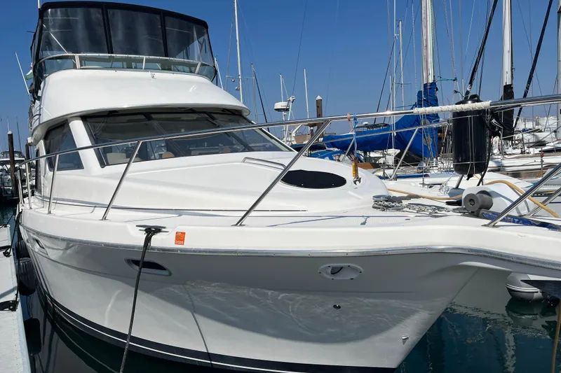 Slide: The Image of 1996 Bayliner 3788 Command Bridge Motoryacht docked at marina, clear sky background. - 46