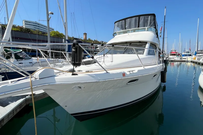 Slide: The Image of 1996 Bayliner 3788 Command Bridge Motoryacht docked in a marina under clear blue skies. - 47
