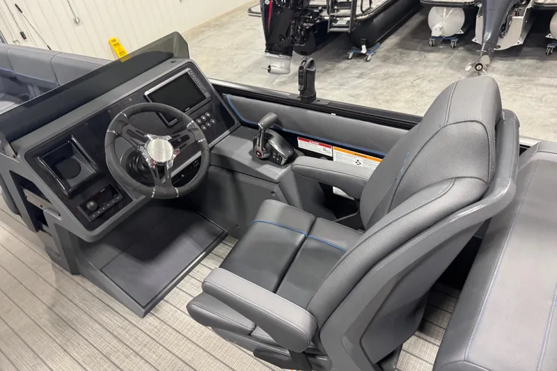 Slide: The Image of 2025 Manitou 24 Explore boat interior with modern steering and control panel. - 11