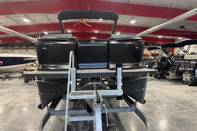 Slide: The Image of 2025 Manitou 24 Explore pontoon boat in showroom, rear view. - 5