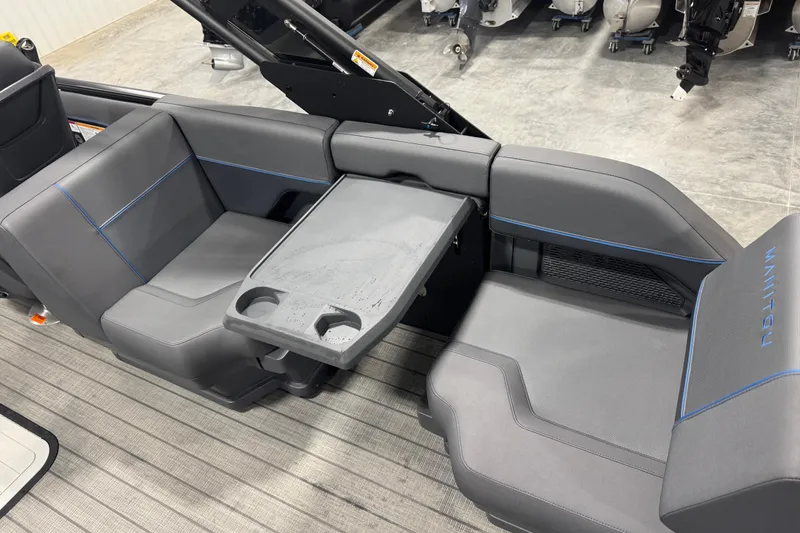 Slide: The Image of 2025 Manitou 24 Explore boat interior with gray seating and integrated table. - 8
