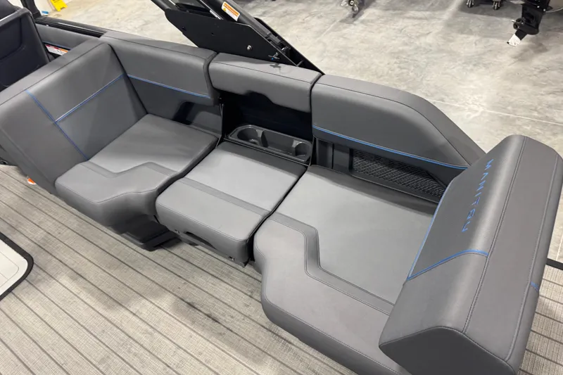 Slide: The Image of 2025 Manitou 24 Explore boat interior with sleek gray seating and blue accents. - 9