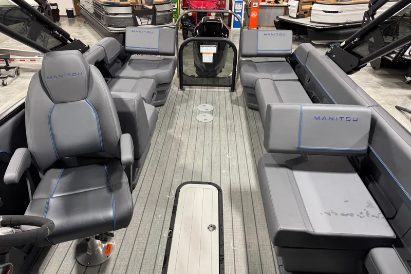 Slide: The Image of 2025 Manitou 24 Explorer boat interior with gray seating and modern design. - 11