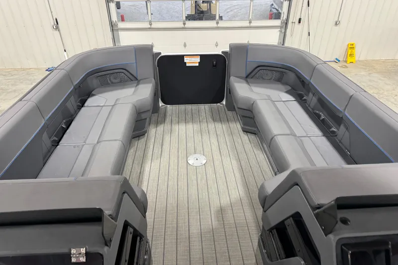 Slide: The Image of Interior of 2025 Manitou 24 Explorer boat with spacious seating and modern design. - 12