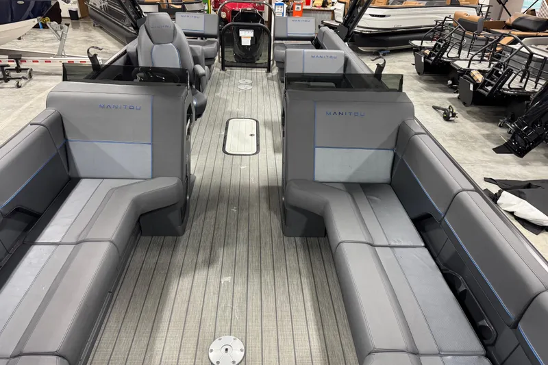 Slide: The Image of 2025 Manitou 24 Explorer boat interior with gray seating and sleek design. - 16