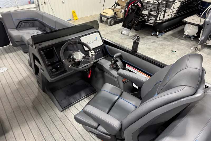 Slide: The Image of 2025 Manitou 24 Explorer boat interior with Garmin navigation system and modern steering console. - 9