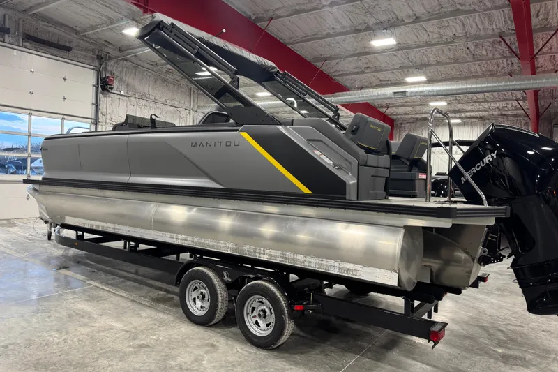 Slide: The Image of 2024 Manitou 24 Explorer pontoon boat on trailer in indoor storage facility. - 4