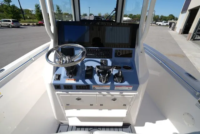 Slide: The Image of The image shows the helm of a 2027 Cobia 245 Center Console boat. - 19