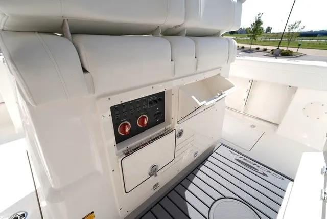 Slide: The Image of Cobia 245 Center Console 2027: Control panel with switches and storage, surrounded by white upholstery. - 21