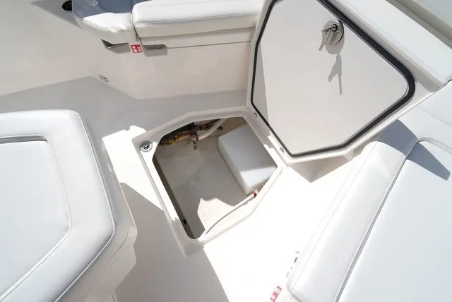 Slide: The Image of The image shows the interior of a Cobia 245 Center Console boat with an open storage compartment. - 29