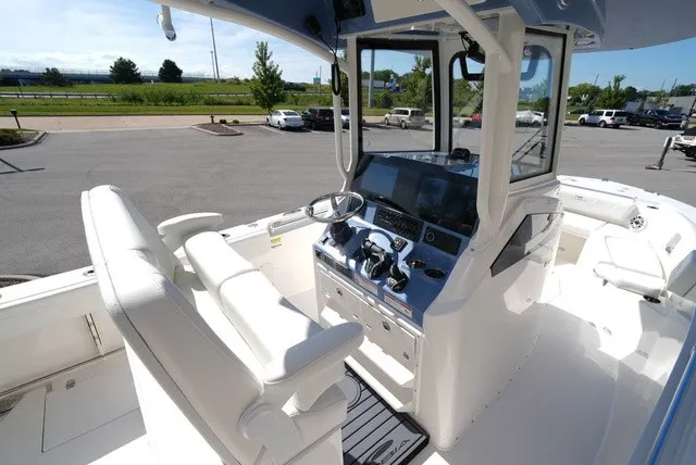 Slide: The Image of The image shows the cockpit of a 2027 Cobia 245 Center Console boat with modern instruments. - 18
