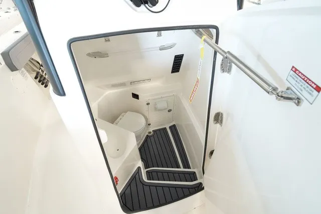 Slide: The Image of Interior view of a 2027 Cobia 265 Center Console with a toilet and non-slip flooring. - 44