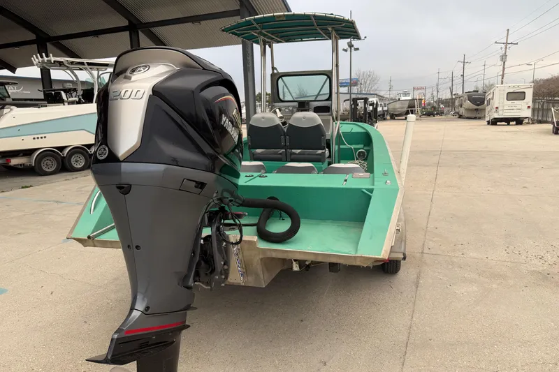 Slide: The Image of A 2012 Charles Leonard 24 boat with Yamaha 200 outboard motor, parked outdoors. - 3